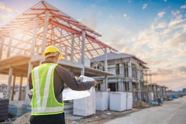 An experienced general contractor in Oakland, CA reviewing blueprints at a home construction and remodeling site